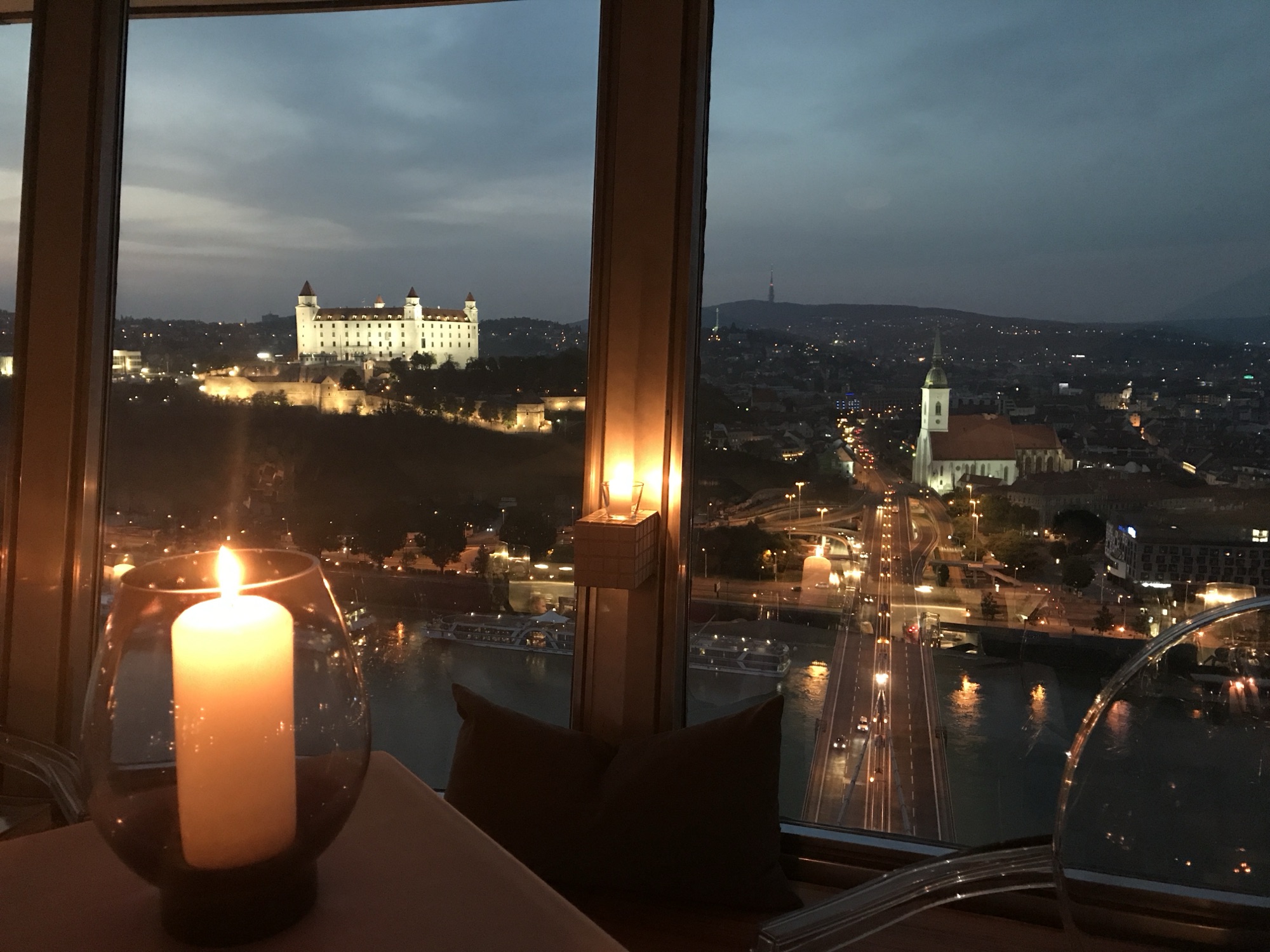 Bratislava Castle and St. Martin’s Cathedral illuminated at night, viewed by candlelight from the UFO restaurant