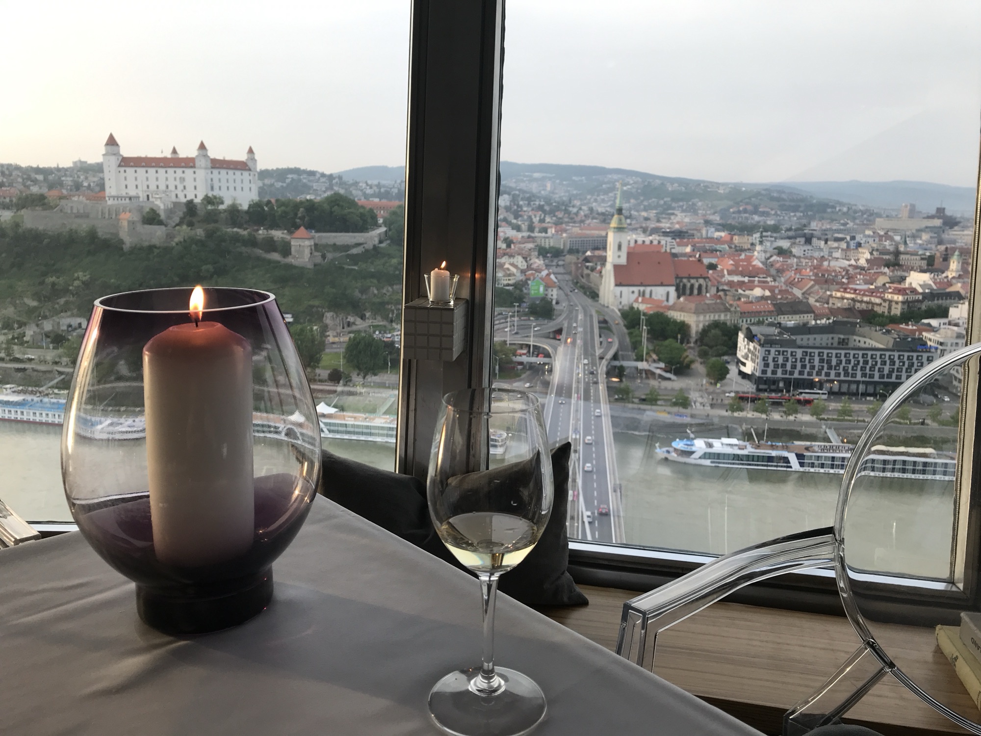 Candlelit table at the UFO restaurant overlooking Bratislava Castle and the Old Town at dusk